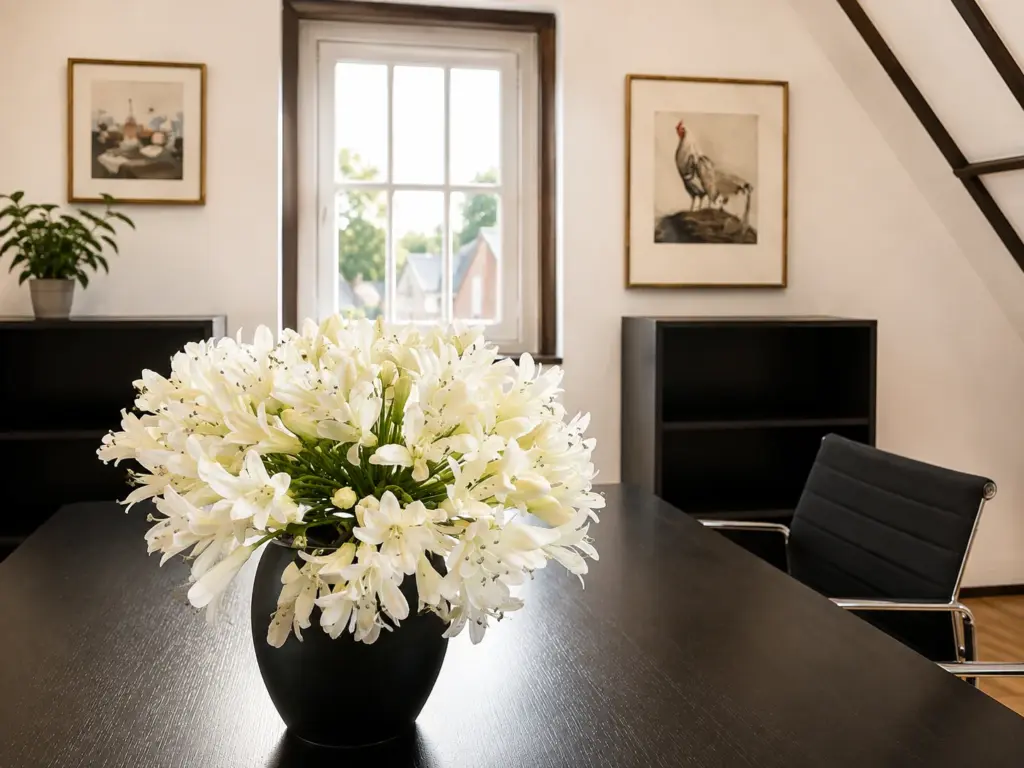Detailaufnahme mit weißen Blumen auf dem Besprechungstisch der Dachwerk-Suite